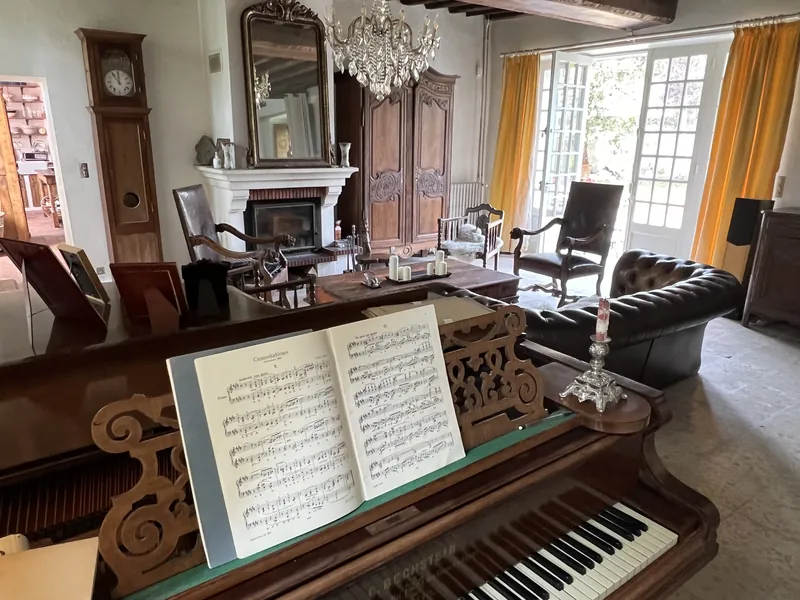 Le piano à queue Bechstein, partition ouverte, face au salon